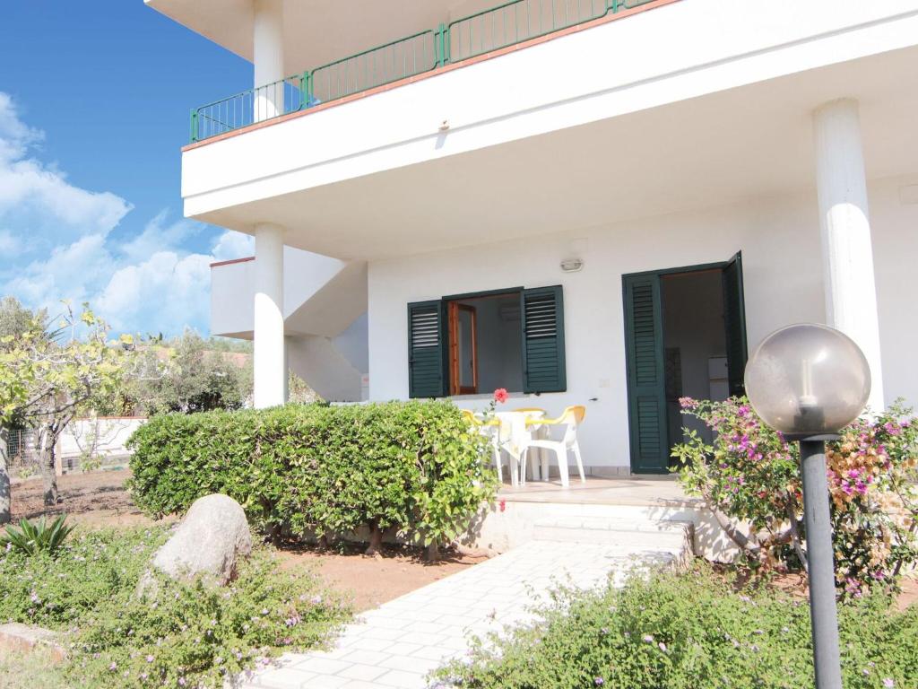 uma casa branca com persianas verdes e um pátio em Nice residence in San Nicol di Ricadi with pool em Ricadi