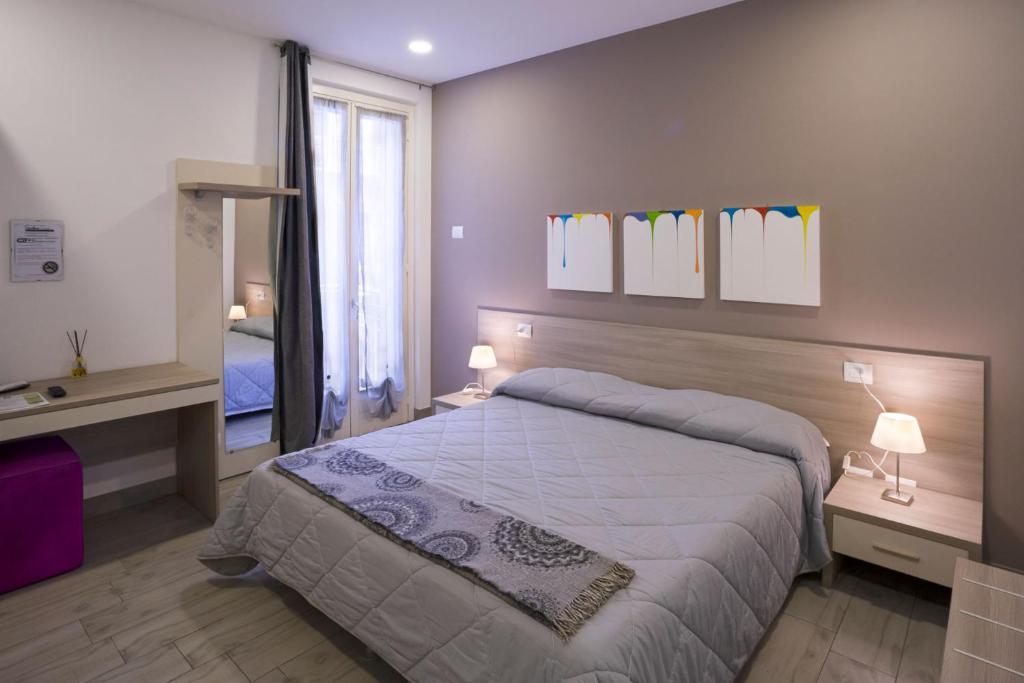 a bedroom with a large bed and a mirror at Ventitrémarzo Guest House in Novara