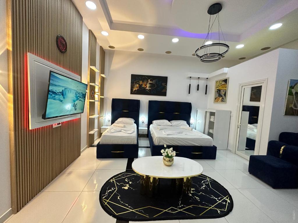 een hotelkamer met 2 bedden en een tafel bij ESTO's Apartament near Tirana Airport 1 - Self CheckIN -Netflix - FREE Parking in Valjiosi
