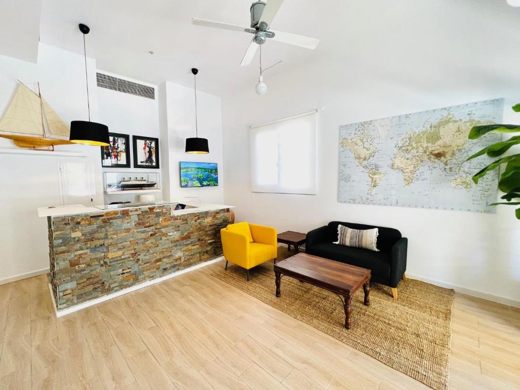 uma sala de estar com um sofá e uma cadeira amarela em Apartamentos Hotel Puente de Hierro em Benicàssim