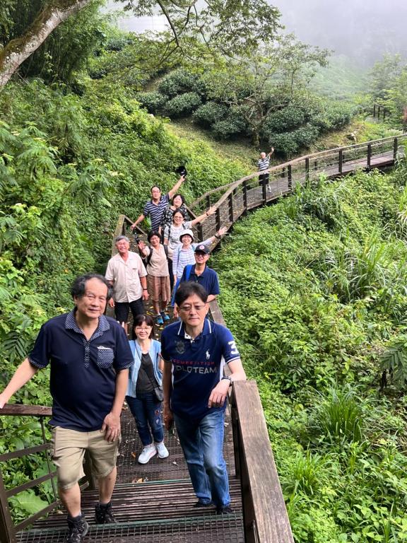 a group of people walking down a wooden bridge at Tianyi Homestay in Fenqihu