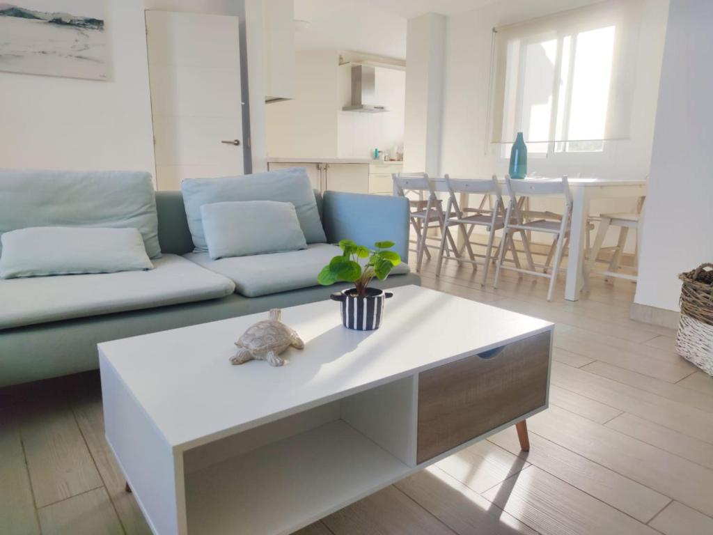 un soggiorno con divano e tavolo di ATICO con vistas al mar a 100 metros de la playa a Torre de Benagalbón