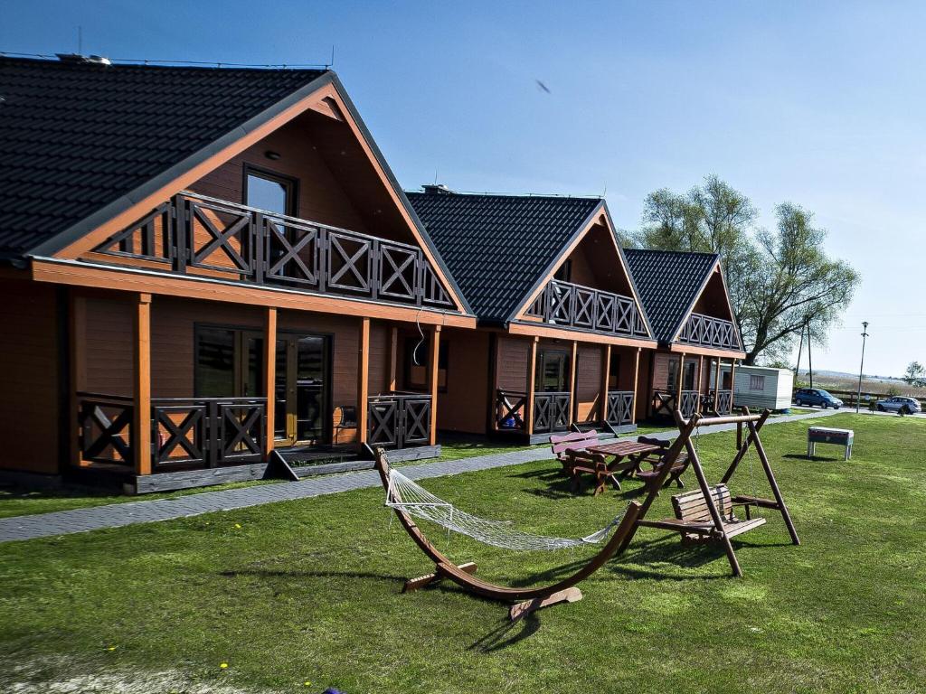 a large house with a hammock in front of it at Sea view holiday home in Mielno with balcony in Mielno