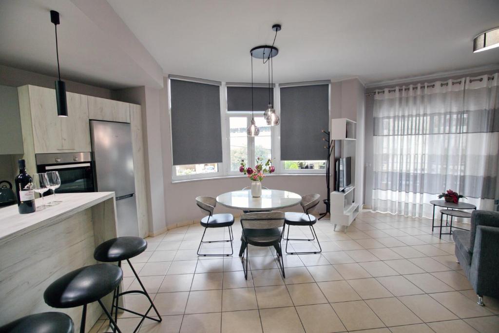 Ioanna's Luxury Two Bedroom Apartment في نافبليو: مطبخ وغرفة معيشة مع طاولة وكراسي
