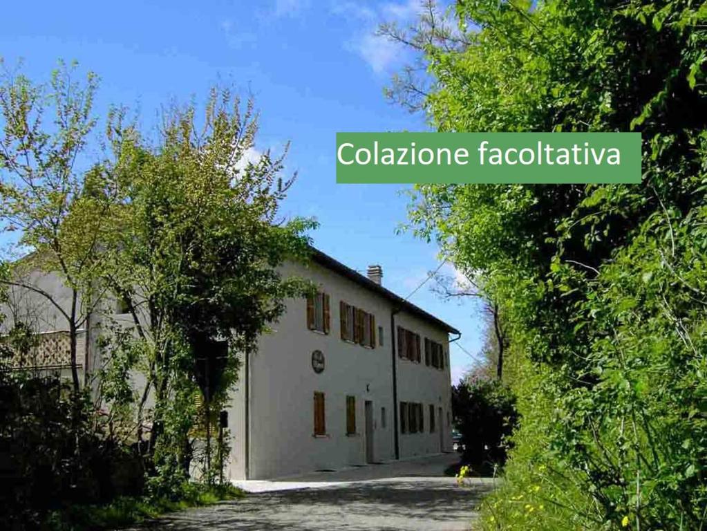 un edificio blanco con las palabras fachada colombiana en Country House-B&B-Appartamenti Ai Cipressi en Urbino