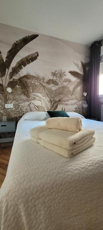a bedroom with a bed with two towels on it at SUITE HAUS Catedral in Santander