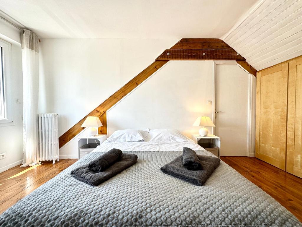 a bedroom with a bed with two towels on it at Maison de pêcheur - À 200m de la plage in Ploemeur