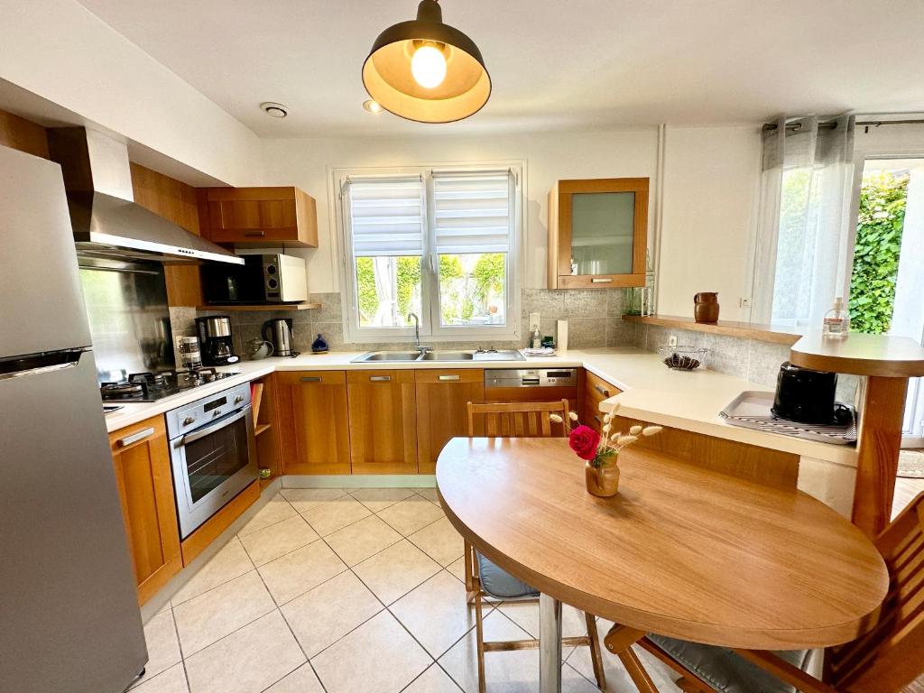 a kitchen with a wooden table and a dining room at Maison de pêcheur - À 200m de la plage in Ploemeur