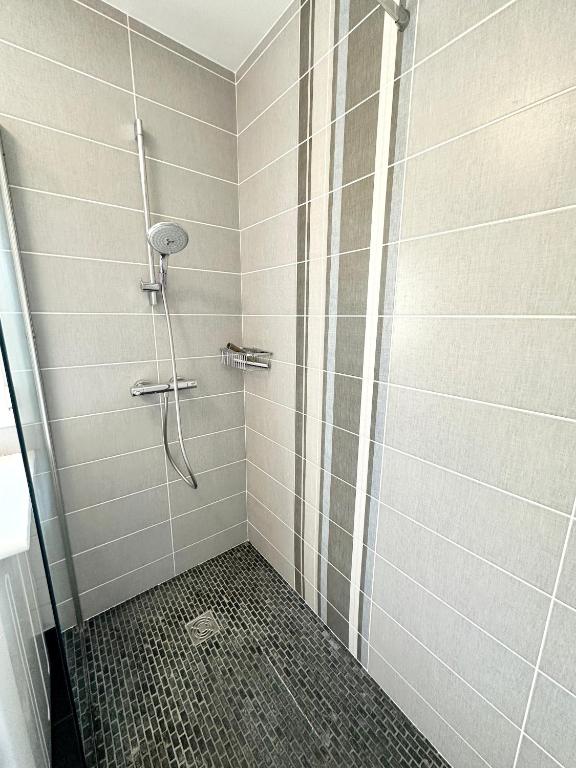 a shower with a glass door in a bathroom at Maison de pêcheur - À 200m de la plage in Ploemeur