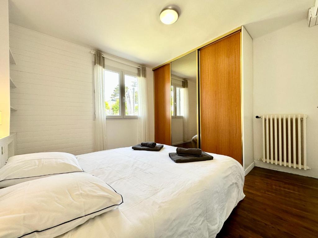 a bedroom with a large white bed with two towels on it at Maison de pêcheur - À 200m de la plage in Ploemeur