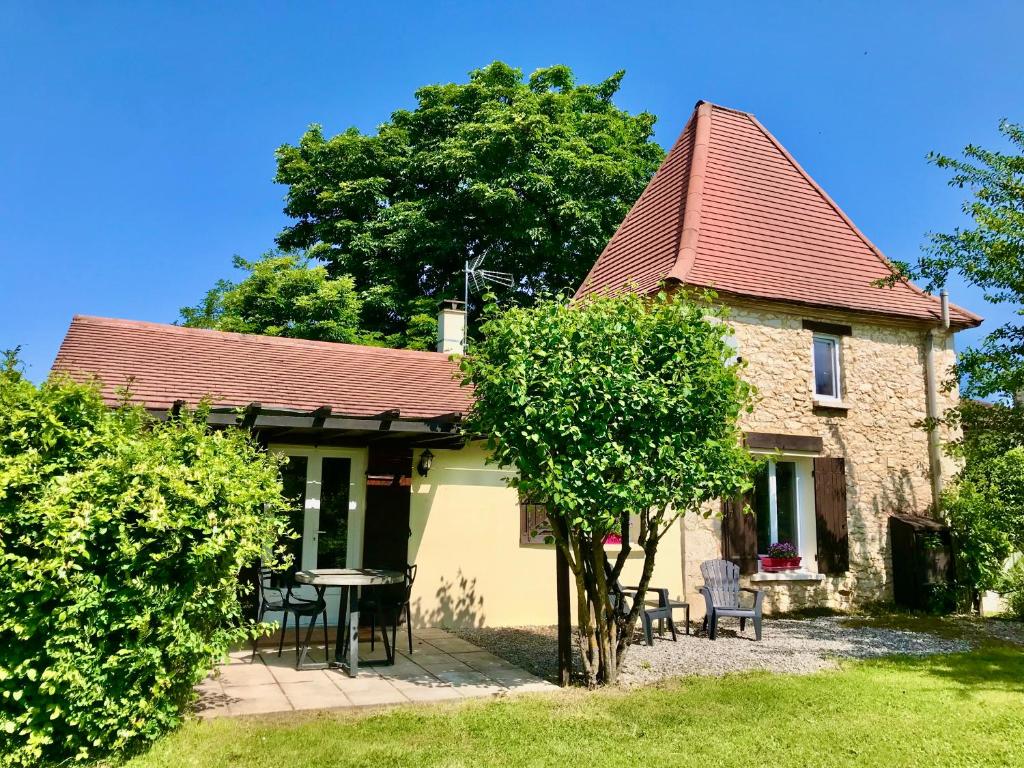 une maison avec une table et des chaises devant dans l'établissement Labarthe Gites Pigeonnier, à Saint-Aubin-de-Cadelech