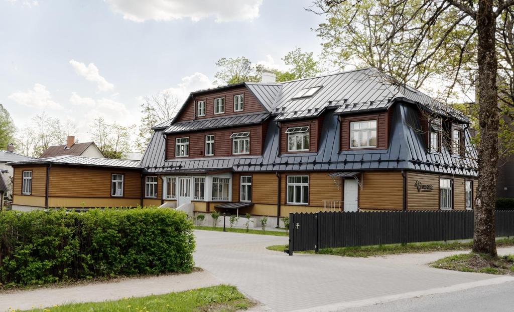 a large wooden house with a black roof at Verona Apartments in Paide