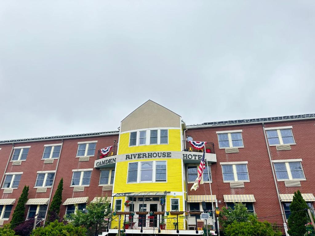 a yellow building on the side of a building at Camden Riverhouse Hotel and Inn in Camden