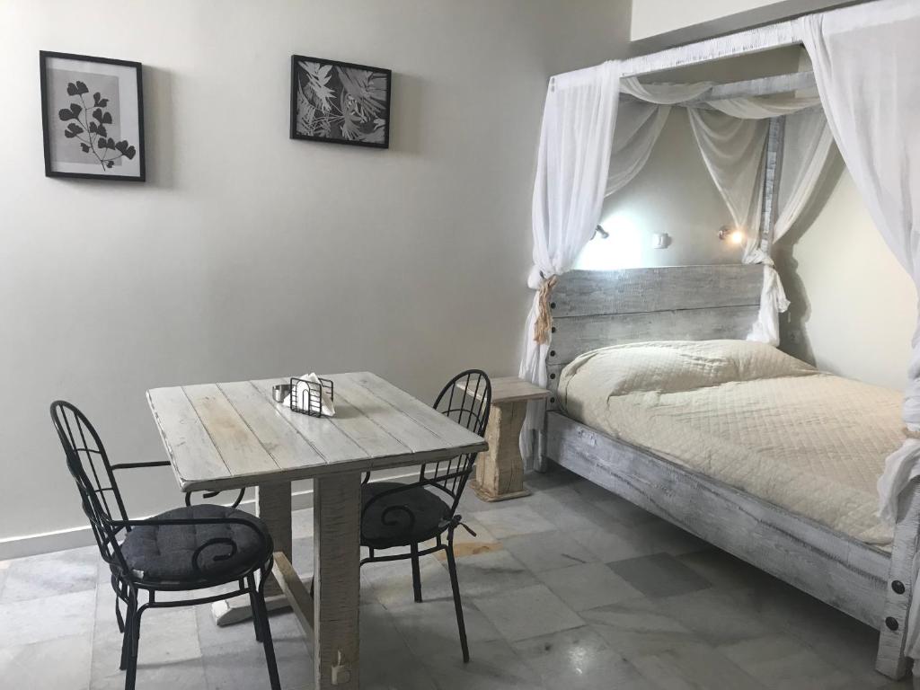Schlafzimmer mit einem Bett und einem Tisch mit Stühlen in der Unterkunft Magia in Galini