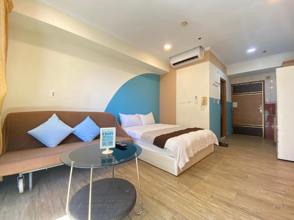 a bedroom with a bed and a couch and a table at Kaohsiung Morning Homestay in Kaohsiung