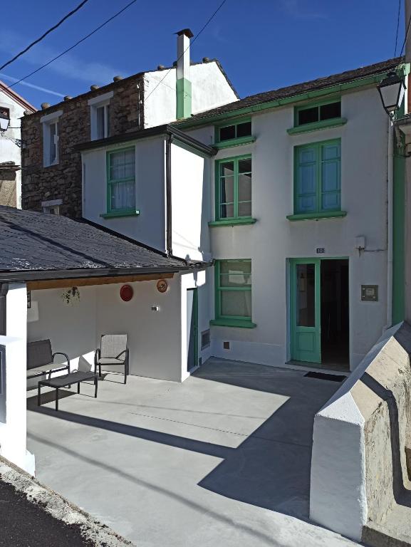 Cette maison blanche dispose de portes vertes et d'une terrasse. dans l'établissement Casa en Puerto de Bares, à Bares