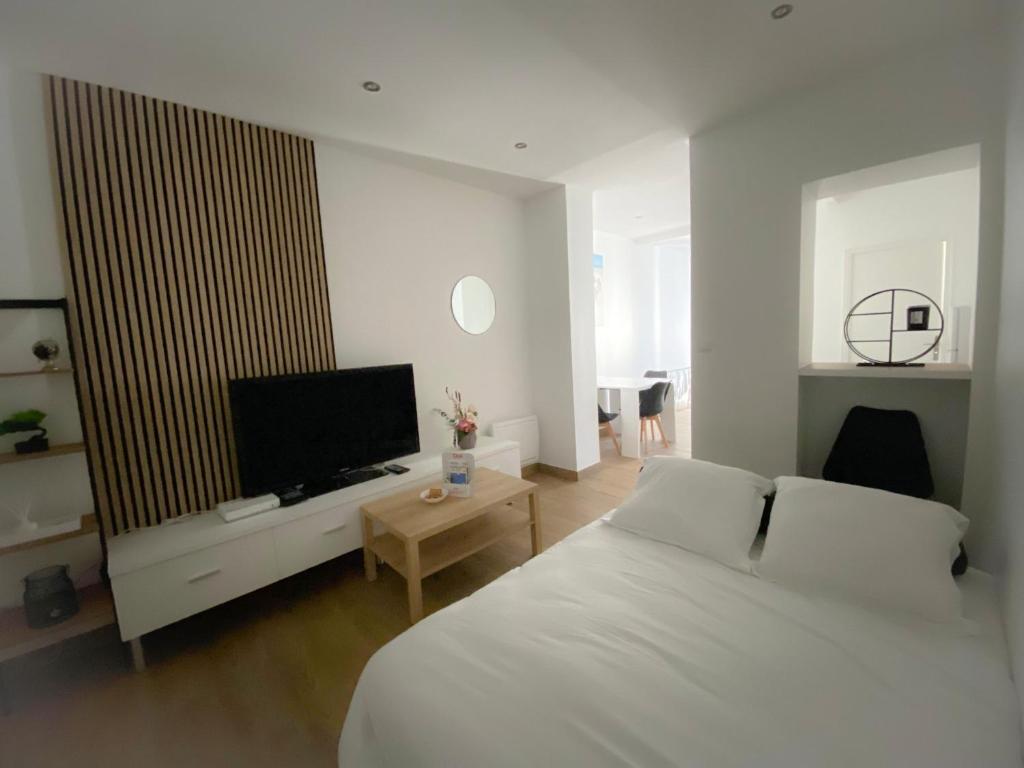 a bedroom with a bed and a flat screen tv at Les Dunes 1 in Sangatte