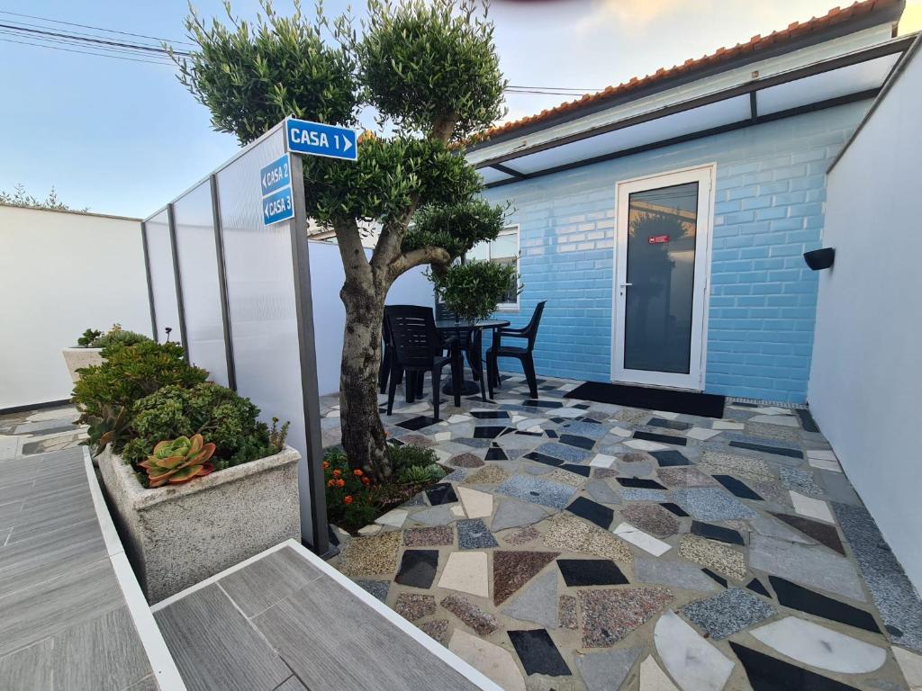 a patio with a tree and a house at Casa de Férias_As Oliveiras I in Espinho