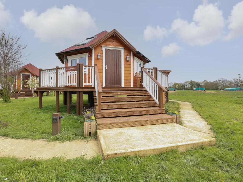 a tiny house with a staircase in a field at Dragonfly Retreat in Pentney