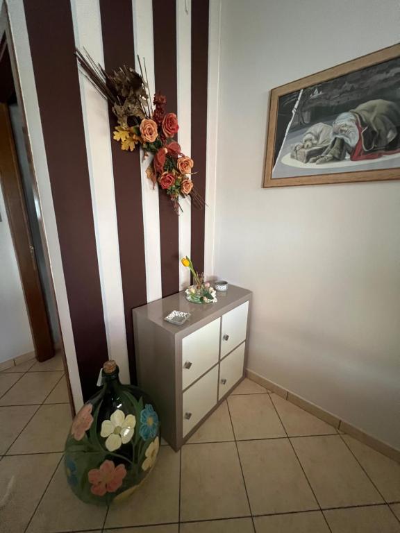 CASA VIA GRAMSCI في مونتيلوبو فيورنتينو: غرفة مع خزانة ملابس وورود على الحائط