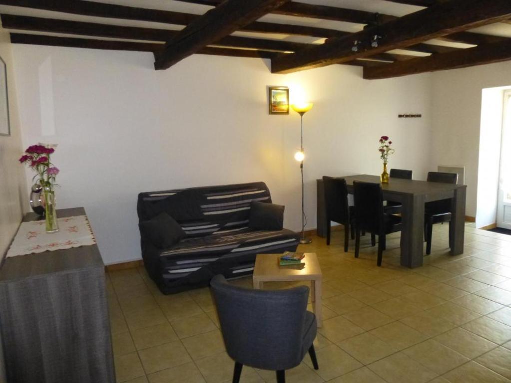 ein Wohnzimmer mit einem Sofa und einem Tisch in der Unterkunft Le moulin neuf - les lilas in Chalandray
