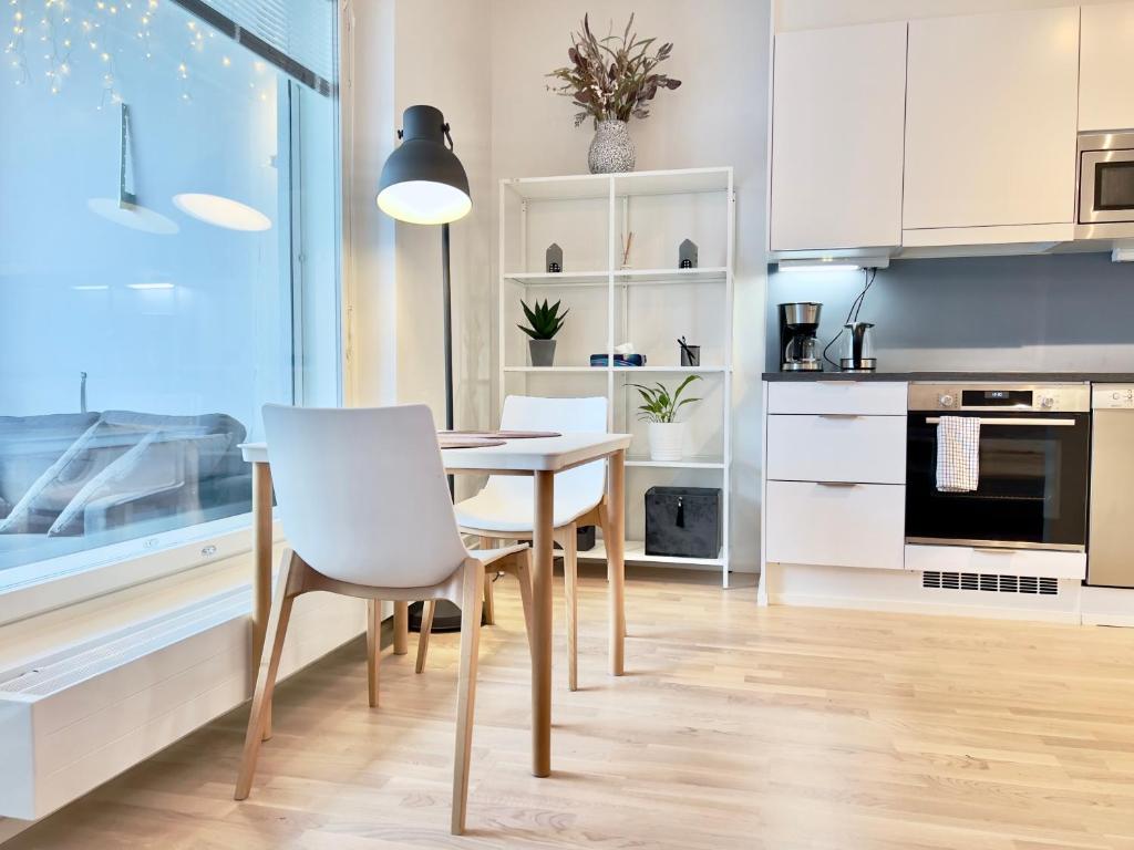 赫爾辛基的住宿－Stunning Central Apartment Helsinki，一间厨房,里面配有桌椅