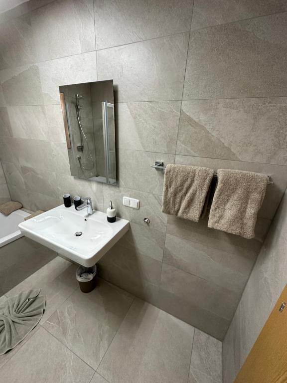 uma casa de banho com um lavatório branco e um espelho. em Apart Bader em Ehrwald