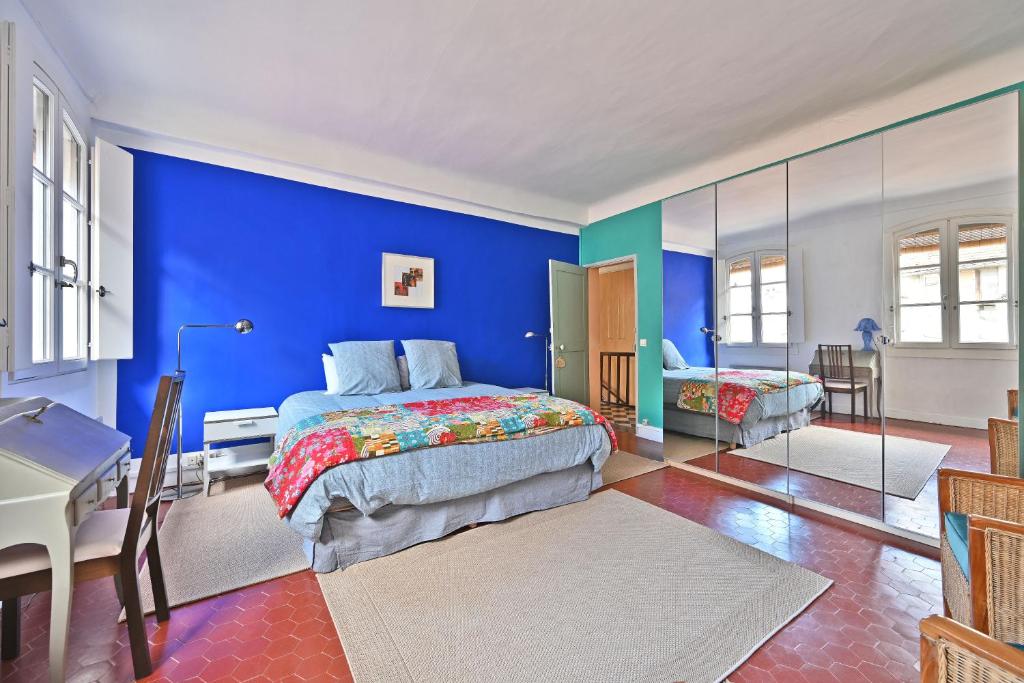 a bedroom with blue walls and a bed and a desk at Les Félibres in Avignon