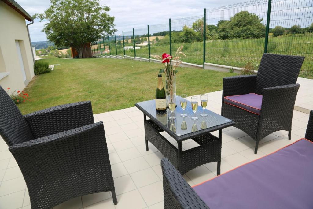 eine Terrasse mit Stühlen und einem Tisch mit Weinflaschen in der Unterkunft Gite montgolfiere in Châtellerault