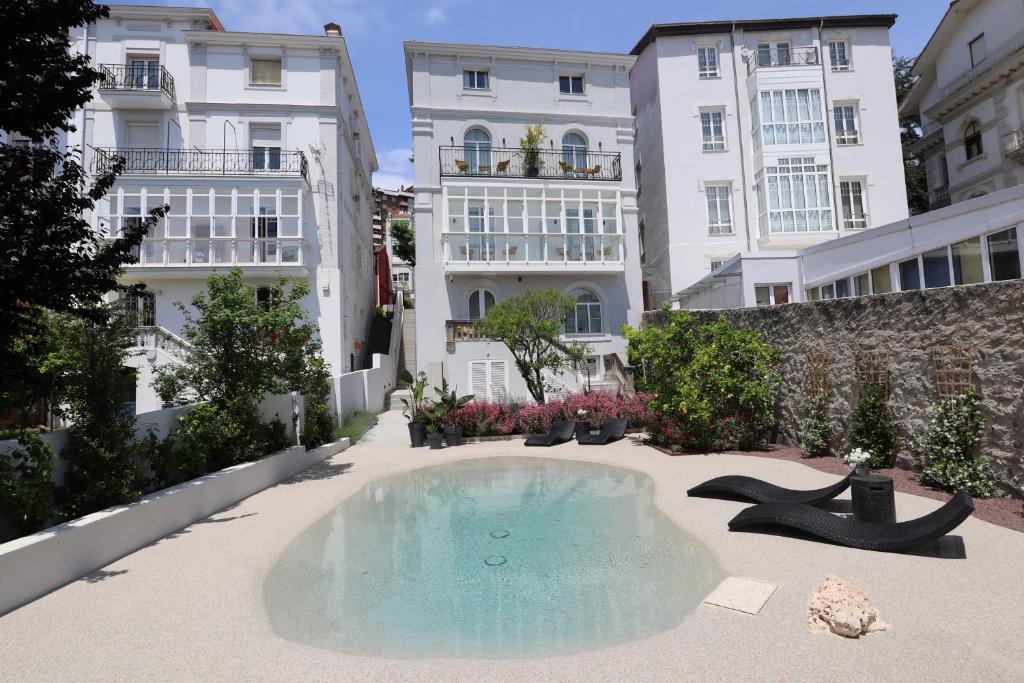 una piscina en un patio con edificios en Sercotel El Balcón de la Bahía Suites, en Santander