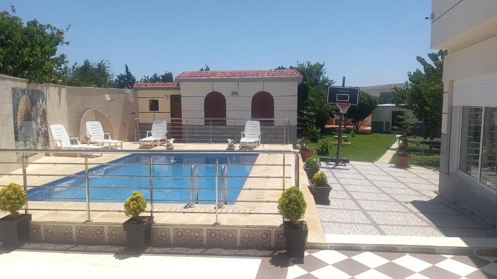 a swimming pool in front of a house at Villa Naima in Larache