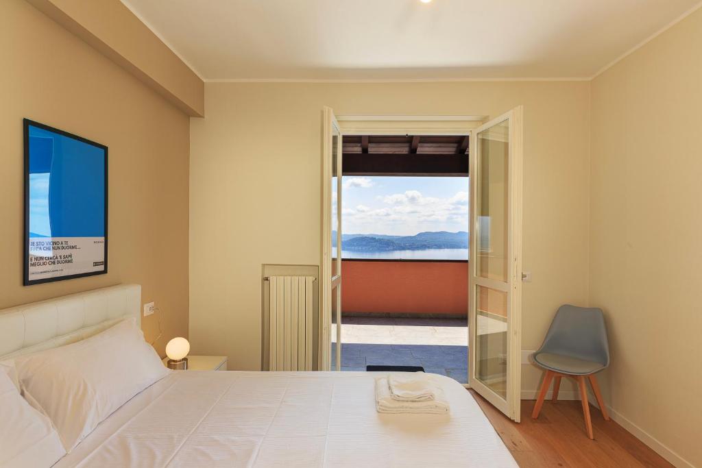 een slaapkamer met een bed en uitzicht op de oceaan bij La Marmotta - Music Home in Belgirate