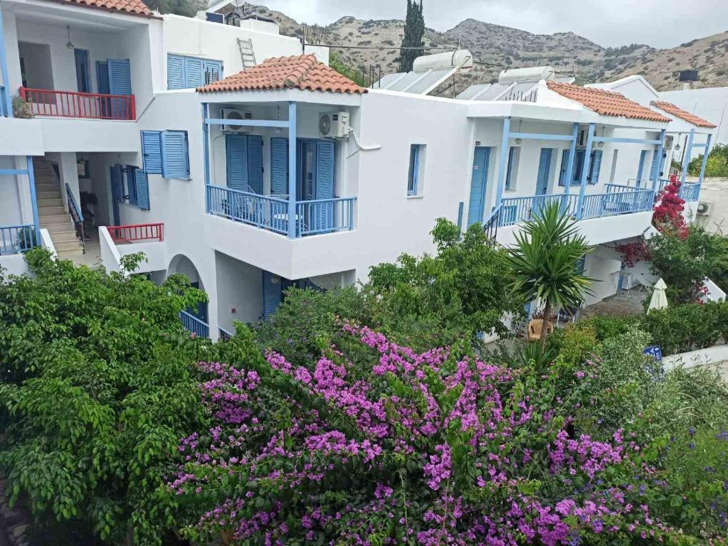 a group of white houses with purple flowers at Villa Mertiza in Myrtos