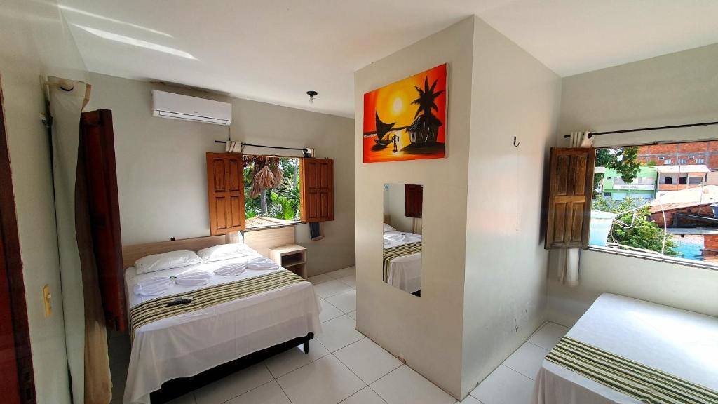 a small bedroom with a bed and a window at Pousada Igarapé in Barreirinhas