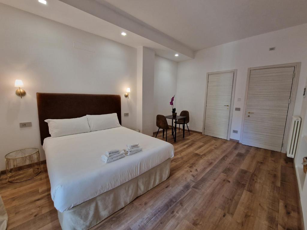 a bedroom with a large bed and a table at Cuma Suites in Rome