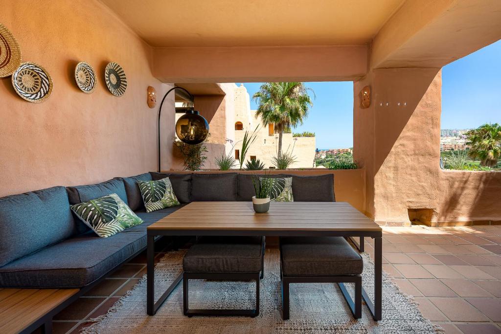 a living room with a blue couch and a table at Coto real Kiznos 2417 Lovely views in San Luis de Sabinillas