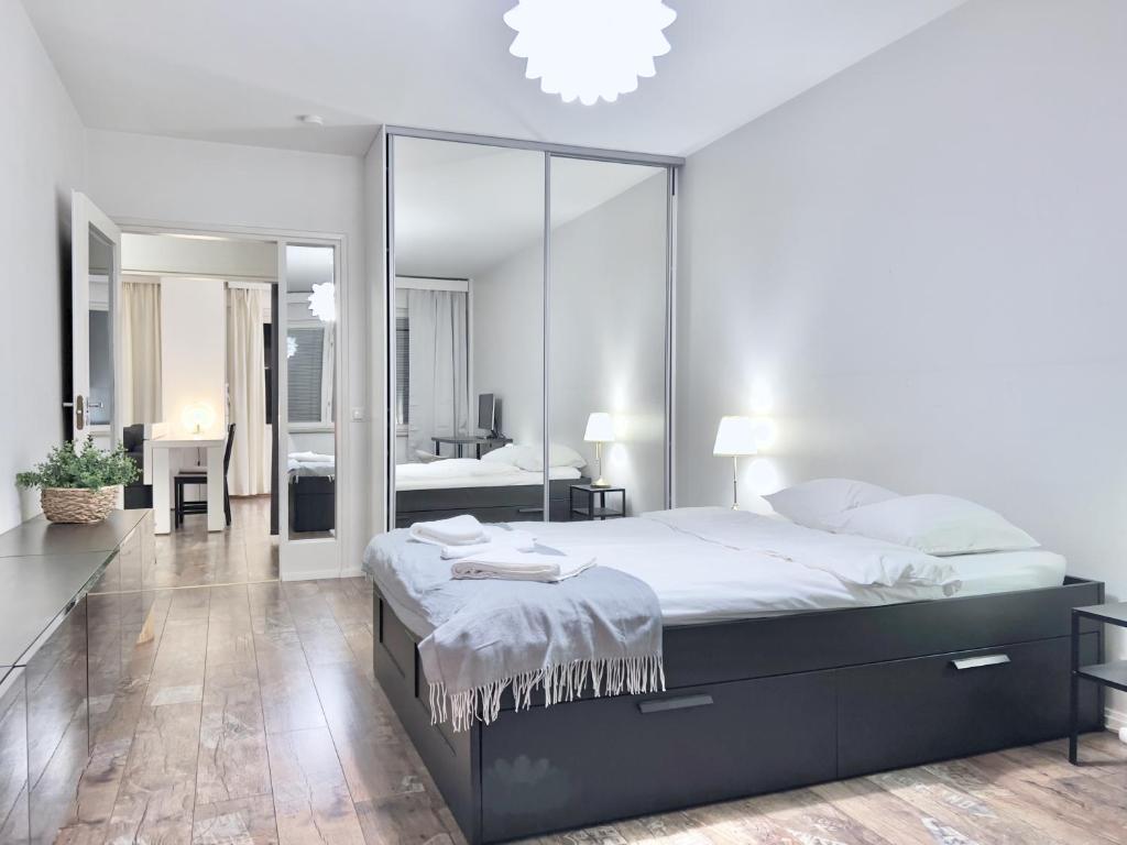 1 dormitorio con 1 cama grande y espejo grande en Fabulous Central Apartment Helsinki, en Helsinki