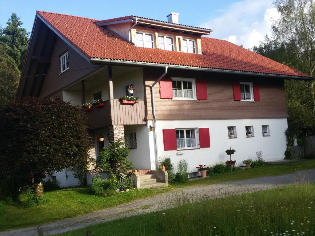 una grande casa con tetto rosso di Ferienwohnung Fritz a Sigmarszell