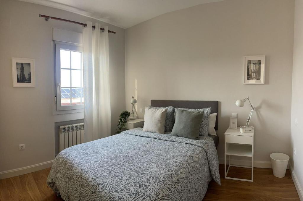biała sypialnia z łóżkiem i oknem w obiekcie Rooms Pilarica w Madrycie