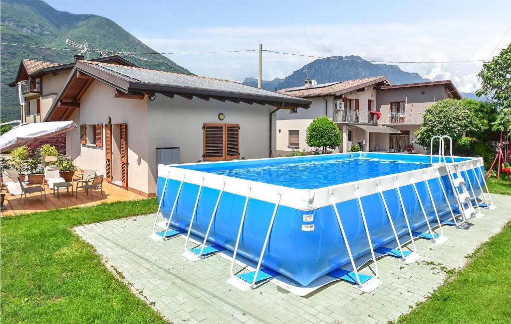 a blue and white swimming pool in front of a house at La Gallina in Artogne