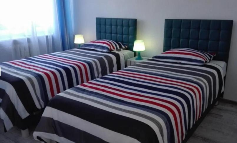 a group of three beds in a room at Apartament w Morskim Stylu in Ustka