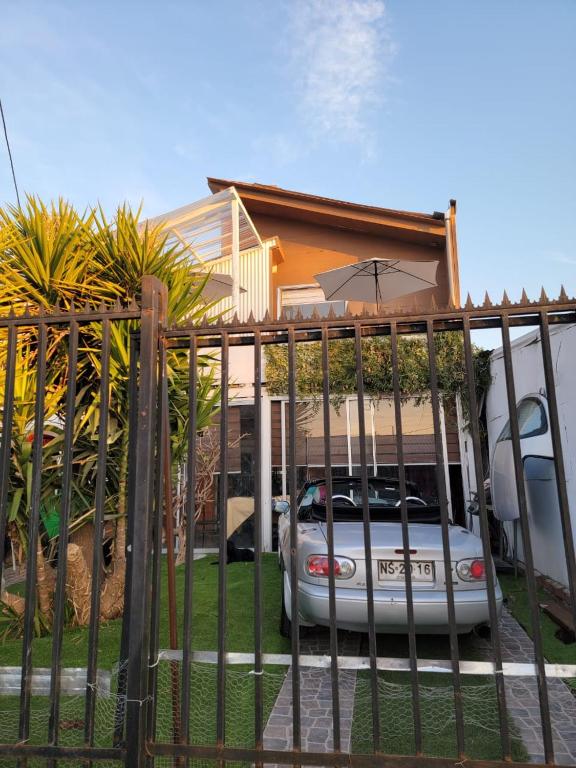 una cerca con un coche estacionado frente a una casa en Hostal Pura Vida, en Santiago