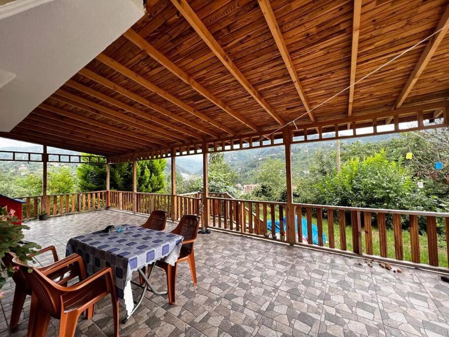 eine Terrasse mit einem Tisch und Stühlen auf einer Terrasse in der Unterkunft Doğa içinde şehir merkezinde in Yomra