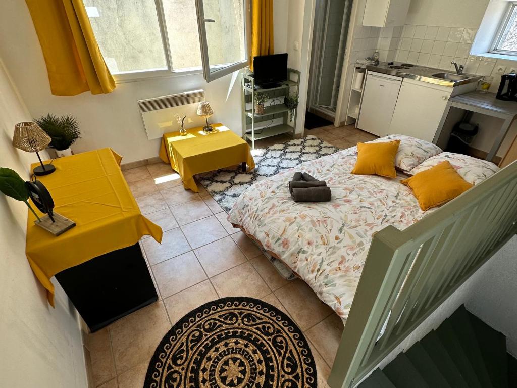 1 dormitorio con cama y mesa amarilla en Face au canal du midi, en Carcassonne