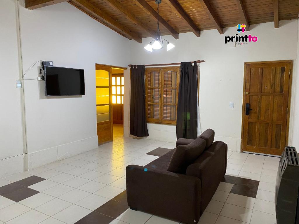 ein Wohnzimmer mit einem Sofa und einem Flachbild-TV in der Unterkunft Una casa amplia y centrica in Tunuyán