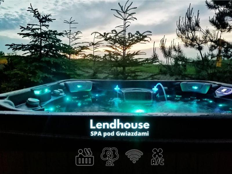 eine Whirlpool-Badewanne mit blauen Lichtern im Hof in der Unterkunft LendHouse - SPA pod Gwiazdami in Sąpów