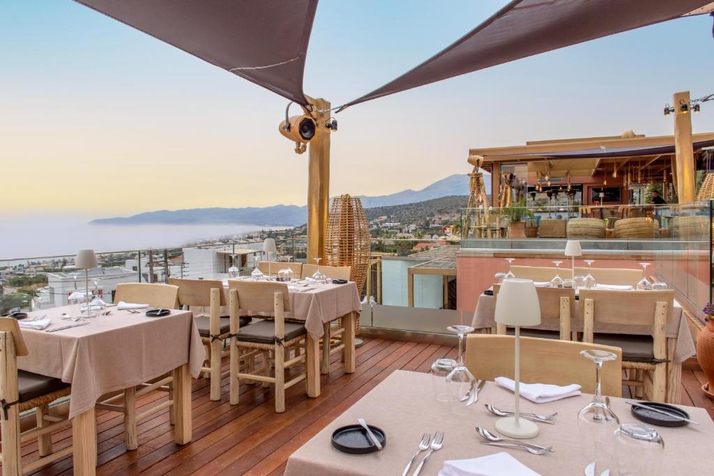 a restaurant with tables and chairs on a balcony at Esperides Resort Crete, The Authentic Experience in Hersonissos