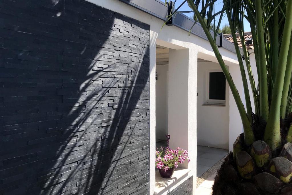 uma sombra numa parede de tijolos ao lado de uma casa em Studio indépendant Pa Ni Pwoblem em Vitrolles