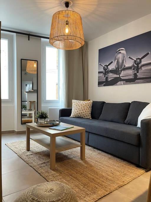 a living room with a blue couch and a table at Appartement T2 La Ferté Gaucher à 200m du centre in La Ferté-Gaucher