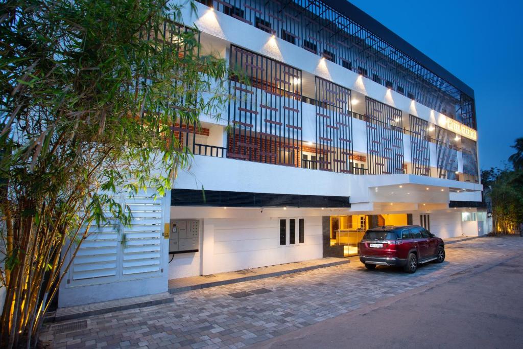 a red car parked in front of a building at Hotel Keerthi in Trivandrum